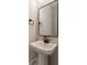 Stylish powder room featuring a pedestal sink, sleek faucet, and a modern black-framed mirror at 576 Reid St, Belmont, NC 28012