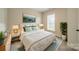 Bright bedroom with white bedding, neutral walls, stylish decor, and natural light from window at 576 Reid St, Belmont, NC 28012