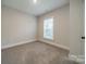 This cozy bedroom has plush carpet, neutral paint, and a bright window at 576 Reid St, Belmont, NC 28012
