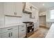 Modern kitchen boasts white cabinets, stainless steel appliances, and a stylish herringbone backsplash at 576 Reid St, Belmont, NC 28012