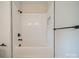 A pristine white tiled shower and bathtub with modern matte black shower head and fixtures at 576 Reid St, Belmont, NC 28012