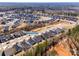 Wide aerial shot of neighborhood with houses, green spaces, and roads with natural features in background at 7133 Yardley St, Gastonia, NC 28056