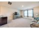 Open living room with neutral carpet, large windows, and media console at 7133 Yardley St, Gastonia, NC 28056