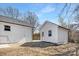 Backyard featuring a white brick detached garage with carriage doors and shed at 7215 Kilcullen Dr, Charlotte, NC 28270