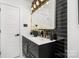 A modern bathroom featuring a double vanity, sleek black tile, and gold fixtures at 7215 Kilcullen Dr, Charlotte, NC 28270