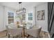 Well-lit dining room with a glass table, designer lighting, and large windows with beautiful views at 7215 Kilcullen Dr, Charlotte, NC 28270