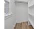 Well-lit walk-in closet with built-in shelving and hardwood floors at 7215 Kilcullen Dr, Charlotte, NC 28270