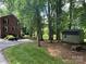Spacious backyard featuring a shed, brick house, fire pit and mature trees offering shade and privacy at 748 Saint Cloud Dr, Statesville, NC 28625