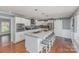 Open concept kitchen features stainless steel appliances, a granite island with seating, and a sliding barn door at 748 Saint Cloud Dr, Statesville, NC 28625