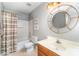 Well-lit bathroom features a bathtub with shower, decorative mirror, and a wooden vanity at 8134 Chatham Oaks Dr, Concord, NC 28027