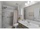 Bathroom featuring a shower with marbled walls and a glass door, plus a modern single sink vanity at 8408 Williamsburg Cir, Huntersville, NC 28078