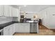 Updated kitchen featuring a breakfast bar and stainless steel dishwasher overlooking the living room at 8408 Williamsburg Cir, Huntersville, NC 28078
