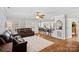 Bright living room featuring hardwood floors, ceiling fan, and seamless flow to the dining area at 8408 Williamsburg Cir, Huntersville, NC 28078