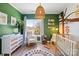 Bright Bedroom with green accent wall, jungle themed art, rocking chair, and natural light at 904 Van Every St, Charlotte, NC 28205