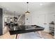 Open floor plan including modern kitchen, staircase, and game room with pool table and view from large windows at 904 Van Every St, Charlotte, NC 28205