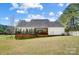 Expansive backyard featuring a well-maintained lawn, screened-in back porch, and white picket fence at 932 Dovefield Dr, York, SC 29745