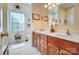 Well-lit bathroom featuring double sinks, wooden cabinets, and a window for natural light at 932 Dovefield Dr, York, SC 29745
