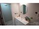 Bright bathroom featuring a white vanity and a sleek, round mirror at 1206 Spring Dr, Shelby, NC 28150