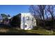 The home features a white brick exterior with green lawn and mature trees surrounding it at 1206 Spring Dr, Shelby, NC 28150