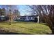 Lawn view of a white brick home with mature trees, showcasing its curb appeal at 1206 Spring Dr, Shelby, NC 28150