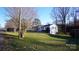 Exterior view of a white brick home with a spacious lawn and mature landscaping at 1206 Spring Dr, Shelby, NC 28150