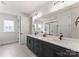 The modern bathroom boasts a double vanity, sleek black hardware, and a large mirror, providing ample space and contemporary style at 12202 Anne Blount Aly, Davidson, NC 28036