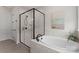Elegant bathroom featuring a soaking tub and a frameless glass shower with marble-style tiling at 12202 Anne Blount Aly, Davidson, NC 28036