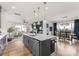 Kitchen island with white countertop, seating, and stainless steel dishwasher, blending seamlessly into the living area at 12202 Anne Blount Aly, Davidson, NC 28036