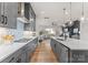 Sleek kitchen with gray cabinetry, stainless steel appliances, a gas cooktop, and a view to the living area at 12202 Anne Blount Aly, Davidson, NC 28036