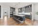 Spacious kitchen featuring gray cabinets, stainless steel appliances, and a large island with seating at 12202 Anne Blount Aly, Davidson, NC 28036