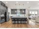Open kitchen with a large island, stainless appliances, gray cabinets, and seamless flow into the living room at 12202 Anne Blount Aly, Davidson, NC 28036
