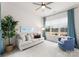 Bright living room with plush sofa, accent chair, and large window with neighborhood view at 12202 Anne Blount Aly, Davidson, NC 28036
