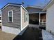 Charming home exterior featuring gray siding, a screened-in porch, and manicured gravel at 134 Cardinal Ave, New London, NC 28127