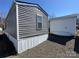 Home exterior with gray siding, adjacent to a white garage, set in a gravel landscape at 134 Cardinal Ave, New London, NC 28127