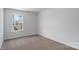 A well-lit bedroom featuring neutral carpeting and a window with neighborhood views at 1346 37Th Avenue Ne Ln, Hickory, NC 28601