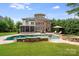 The pool is surrounded by a stone patio, lounge furniture, and a lush lawn at 14314 Lissadell Cir, Charlotte, NC 28277