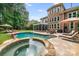 Backyard with a pool and spa, patio with lounge chairs, and outdoor seating with grilling area at 14314 Lissadell Cir, Charlotte, NC 28277