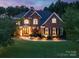 Stunning two-story brick home with manicured lawn, landscape lighting, and mature trees at 14314 Lissadell Cir, Charlotte, NC 28277