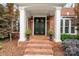 Close up of front door with manicured landscaping and a brick walkway at 14314 Lissadell Cir, Charlotte, NC 28277