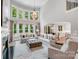 Spacious living room with a fireplace, chandelier, and views of the landscaped yard at 14314 Lissadell Cir, Charlotte, NC 28277