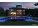 An in-ground swimming pool and hot tub are lit up at twilight in this backyard oasis at 14314 Lissadell Cir, Charlotte, NC 28277