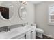 Bright bathroom featuring double sinks, white cabinets, modern fixtures, and a window at 14723 Sapphire Ln, Pineville, NC 28134