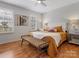 Bright bedroom featuring a woven bench at the foot of the bed, ceiling fan and shuttered windows at 14723 Sapphire Ln, Pineville, NC 28134