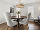 Bright dining room featuring a round wood table, chandelier, four upholstered chairs, and hardwood floors at 14723 Sapphire Ln, Pineville, NC 28134