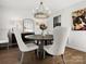 Sunlit dining room boasts a round table with modern chairs, stylish chandelier, and hardwood floors at 14723 Sapphire Ln, Pineville, NC 28134