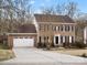 Charming brick home featuring a manicured front lawn, attached two-car garage, and classic colonial architecture at 14723 Sapphire Ln, Pineville, NC 28134