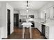 Well-lit kitchen featuring stainless steel appliances, granite countertops, white cabinets, and hardwood floors at 14723 Sapphire Ln, Pineville, NC 28134
