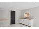 A kitchenette with white cabinets and wood countertops, window, black door, and white floor at 14723 Sapphire Ln, Pineville, NC 28134