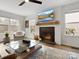 Cozy living room with fireplace, mantel, large windows, ceiling fan, and hardwood floors at 14723 Sapphire Ln, Pineville, NC 28134