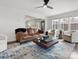 Open living room featuring a ceiling fan, hardwood floors, stylish rug, and a glimpse into the adjacent kitchen at 14723 Sapphire Ln, Pineville, NC 28134